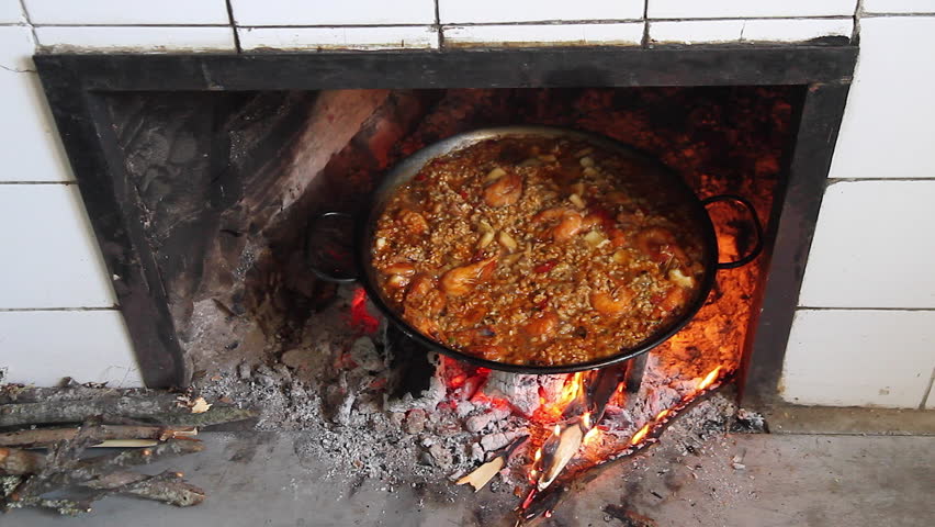 Stock Footage of Cooking a paella - Paella rice cooking on a wood fire in the fireplace in the kitchen