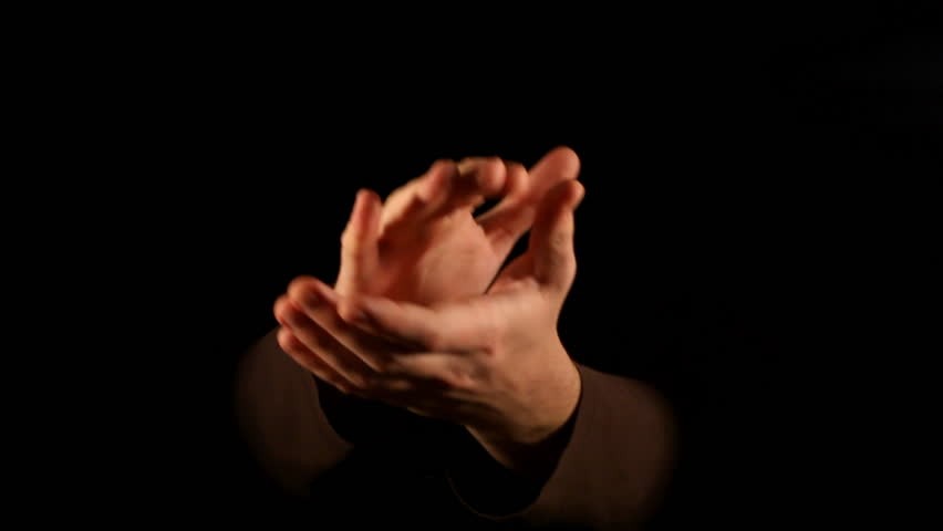 Clapping hands on black background