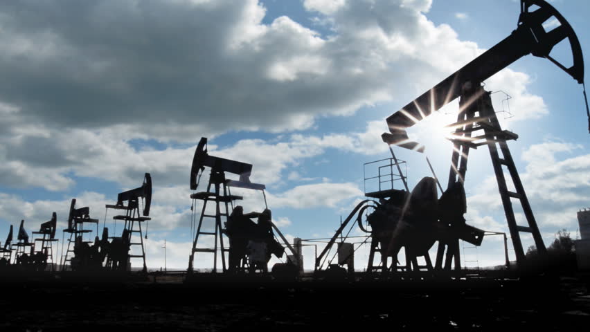 working oil pumps silhouette against timelapse clouds