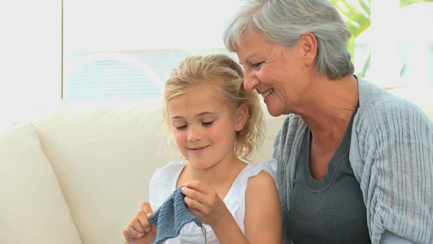 Grandmother teaching her grand daughter how to knit