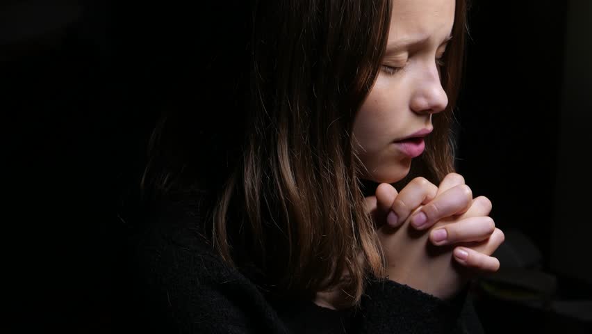 Attractive Young Woman Putting Her Hands Together In Prayer Against A 