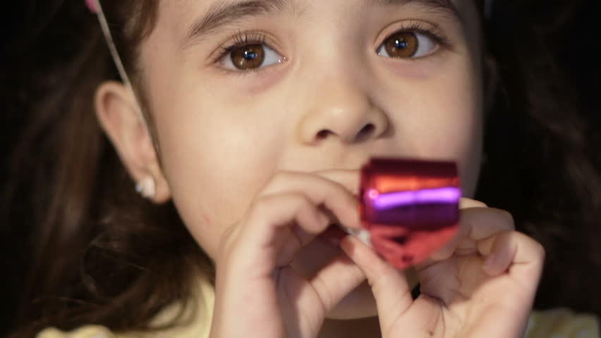 child celebrating with party blower