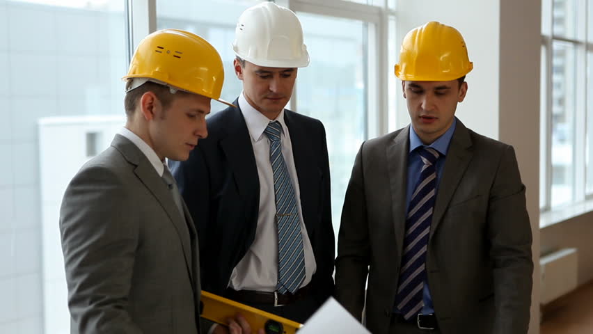 Three builders meeting together and discussing project