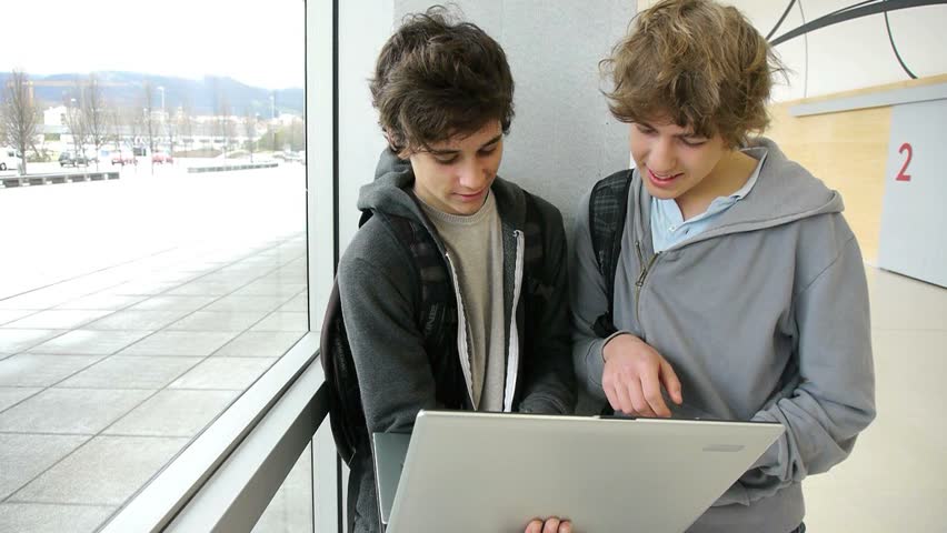 Students with laptop computer in school lounge