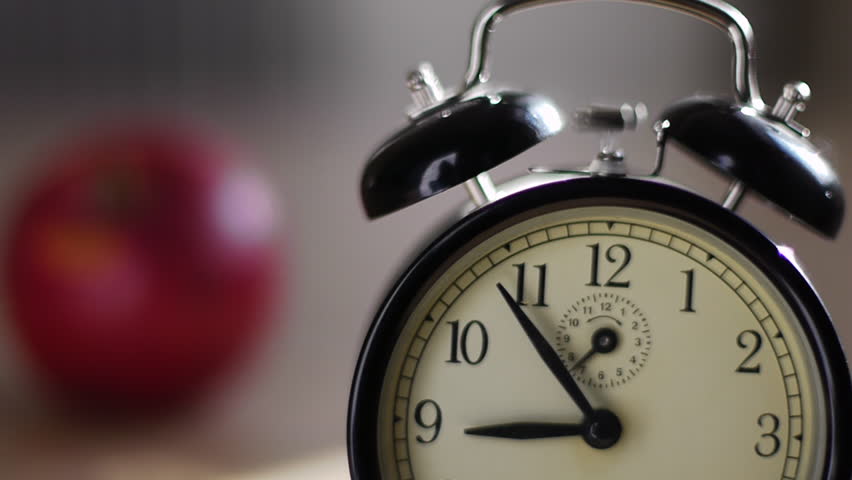 alarm clock going off with tomato in background