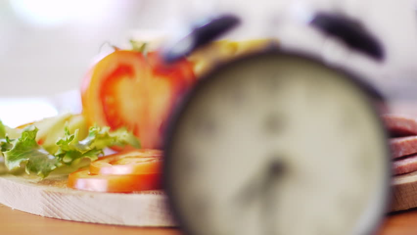 alarm clock going off with tomato in background
