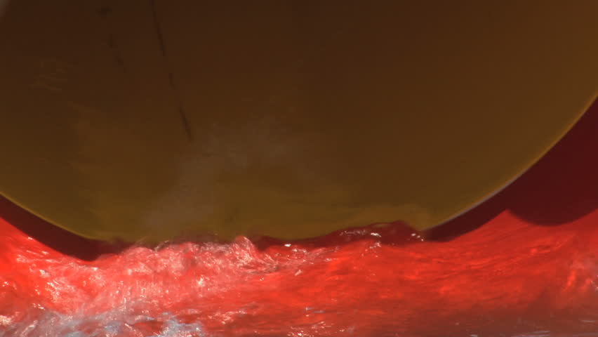 Child comes out from a water slide in an aquatic park; back zoom