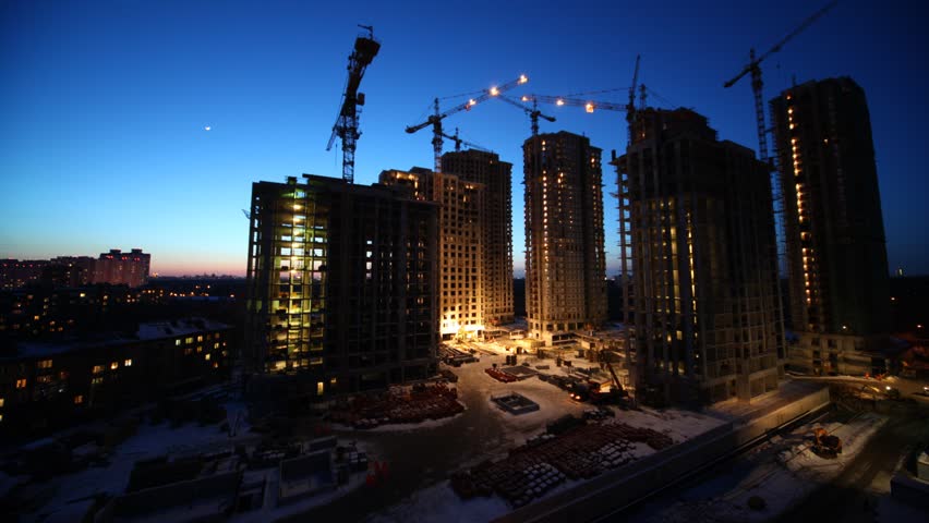 Overview of construction site in evening, time lapse