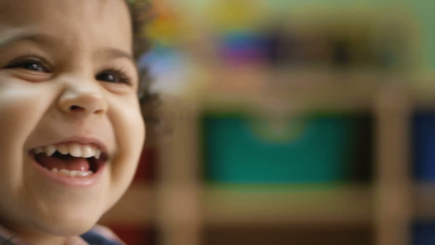 Baby girl laughing, clapping hands and having fun at kindergarten