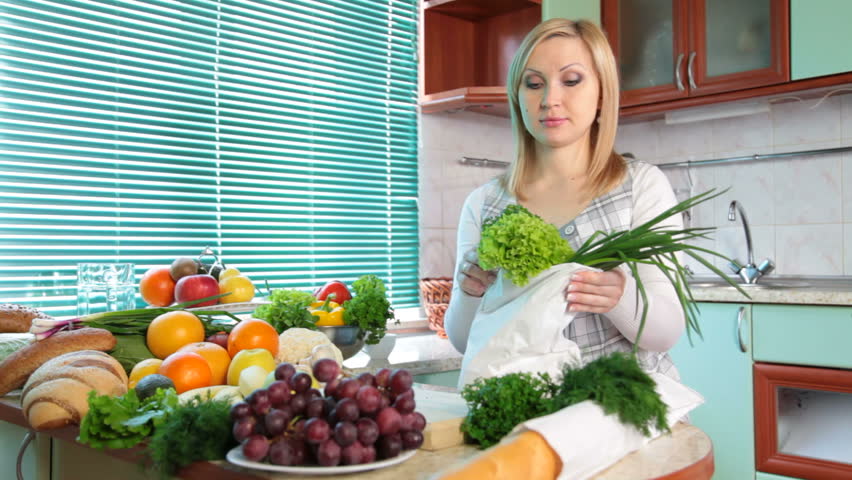 Pregnant woman with Groceries in kitchen