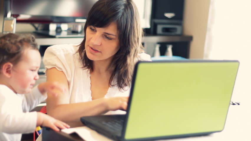 Mother with baby working on the laptop