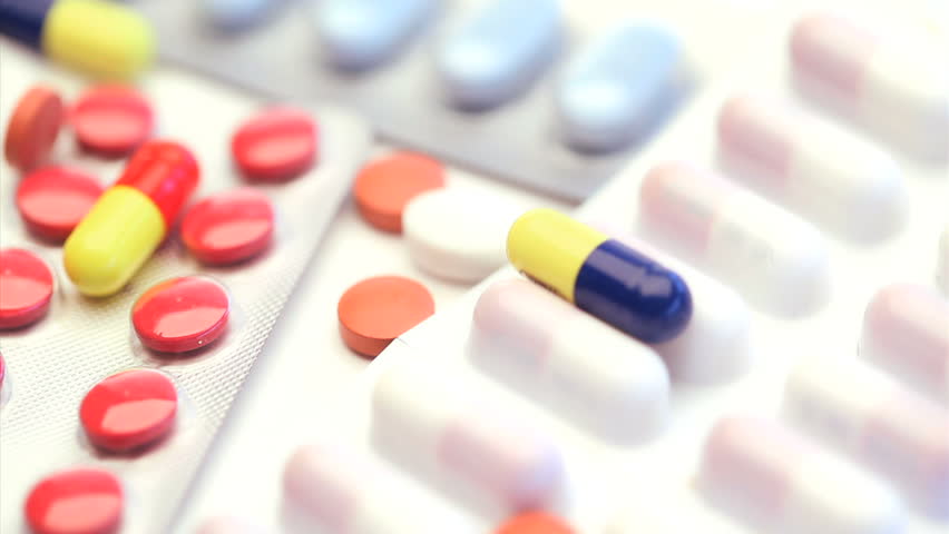Several medicine tablets and pills turning on themselves on a white background