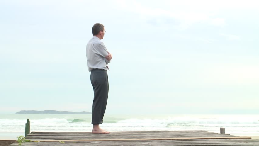 HD 1080i: Depressed barefoot businessman walking at the sea.