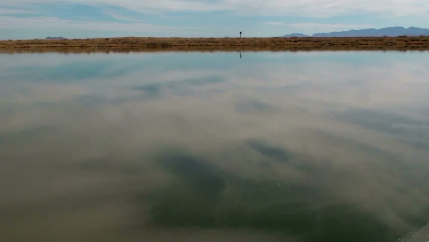 Flat rock tossed, skips across lake, creates ripples. 1920x1080