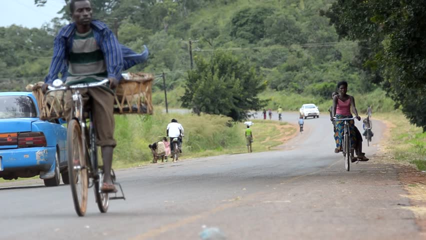 SALIMA, MALAWI - CIRCA APRIL 2011: African cyclists on a main road circa April 2011 in Salima, Malawi. Malawi is among the world's least developed countries; Only about 45 percent of its roads are paved.  