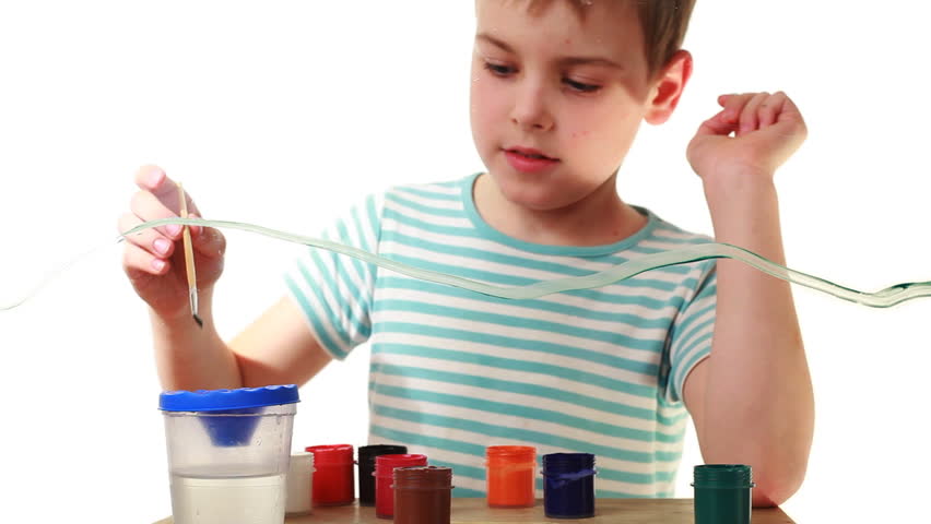 boy washes brush, takes colored paint and begins to draw picture on transparent glass, behind white background
