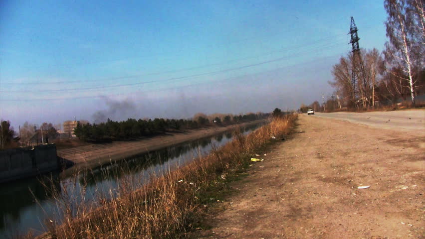 Cars driving on the road near watercourse