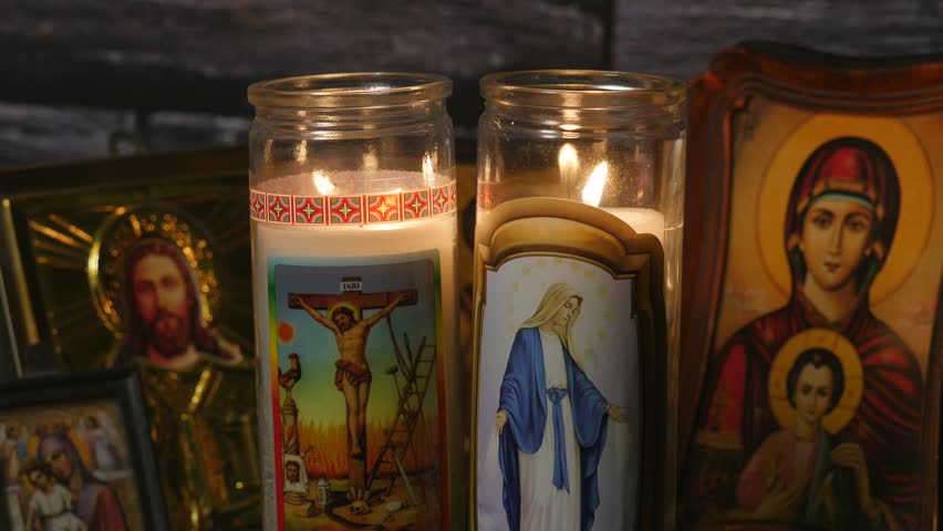 A Christian Icon Of Mother Mary Holding Jesus In Front Of A Candle