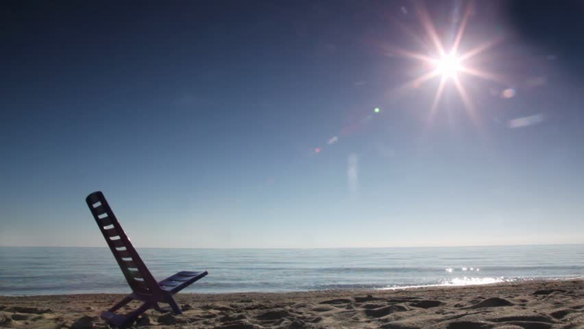Woman came, sit and leaned back on deckchair, deck-chair, on beach at sunny day, sideview