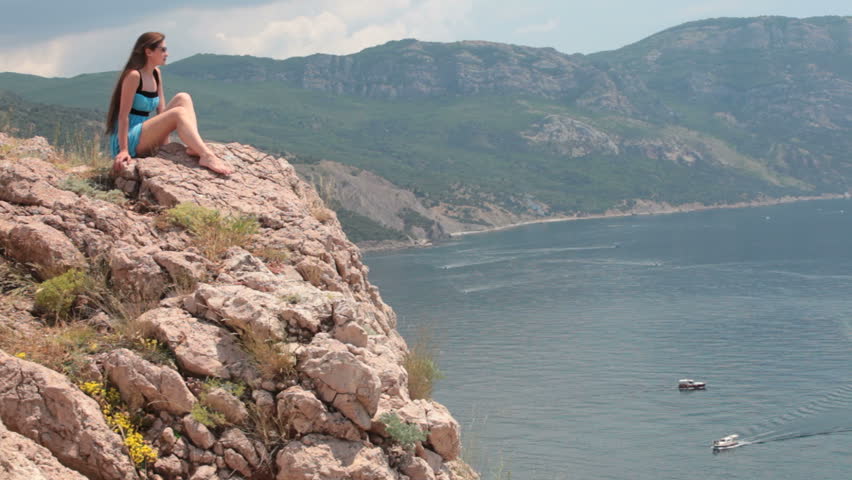 Woman sitting on the edge of a cliff Balaklava, Crimea, Ukraine