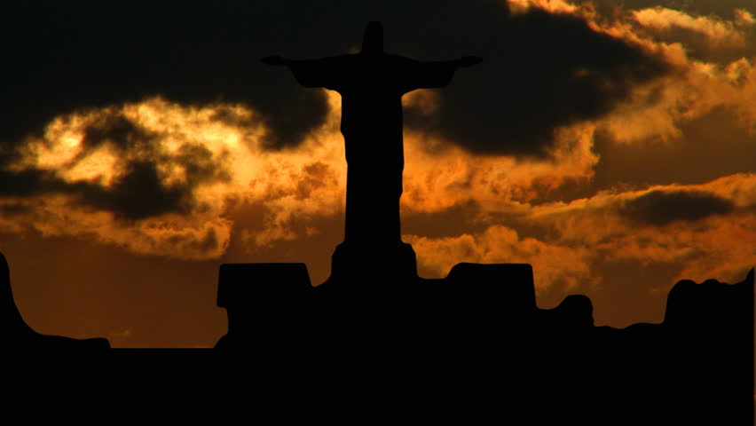 Statue of Christ on Sugar-loaf, in Rio de Janeiro, Brasil, with orange sunset in the background.