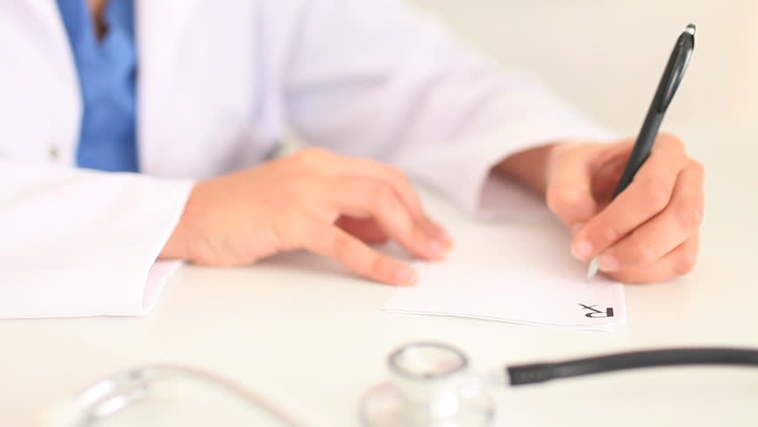 Woman writing a prescription in an office