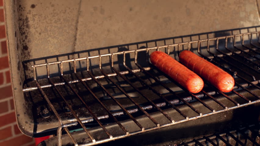 Two hot dogs on top grill rack