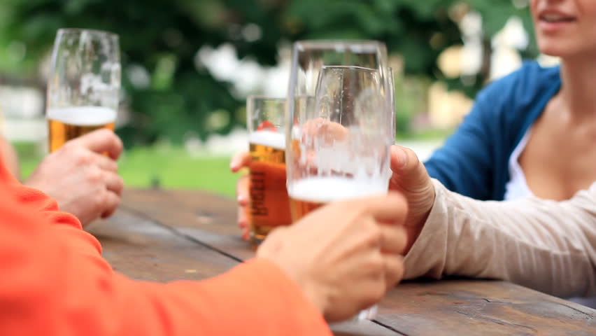 Four friends drinking beer, outdoors 