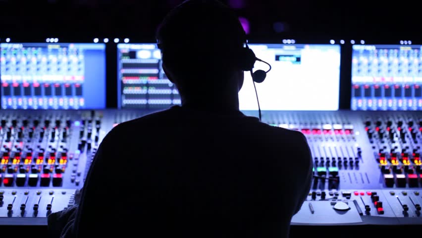 Silhouette of sound producer, which sits at mixer panel