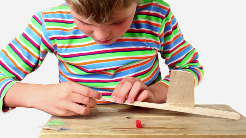 Boy apply adhesive and attach tail to wooden aircraft, he pricked his finger and looked if there was splinter 