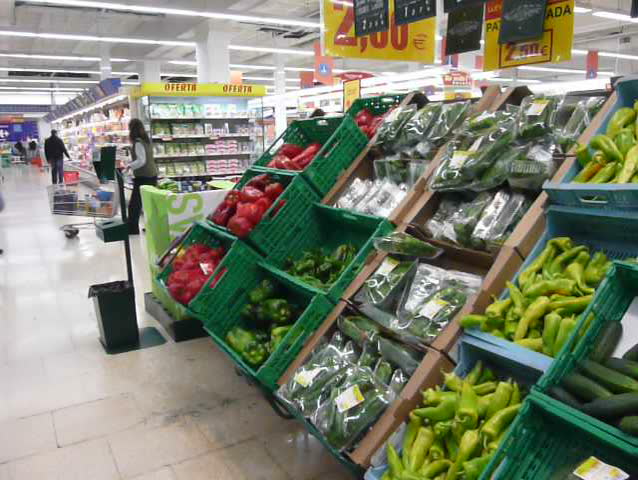 Pan across vegetables, peppers, courgettes and tomatoes in a supermarket
