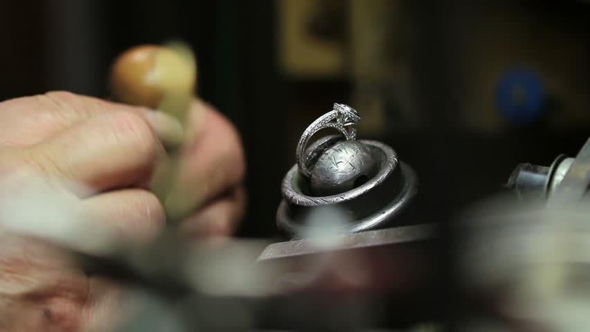 Goldsmith fixing a diamond ring in his shop