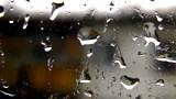 Windowpane with reflexion of a rain, a fog and city street