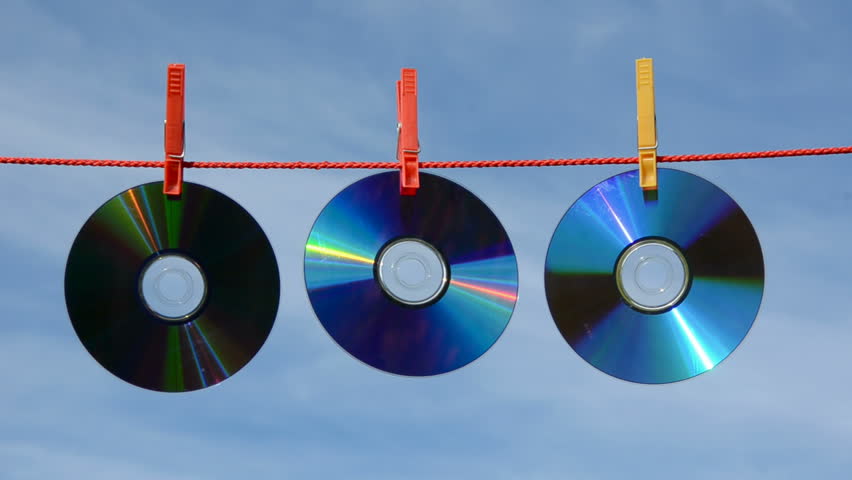 three dvd and cd discs on string and wind