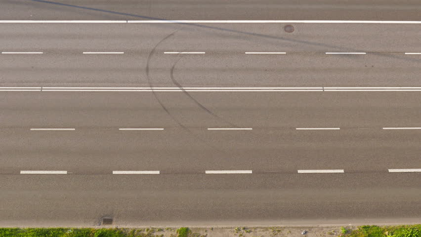 High Angle View Following A Lone Red Car As It Travels Down An Emply