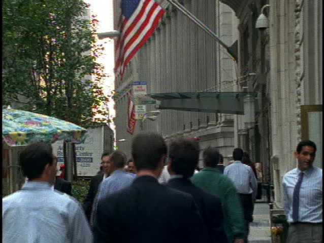 NEW YORK - CIRCA 1990's: Business people walk down a busy New York sidewalk circa 1990's in New York. 
