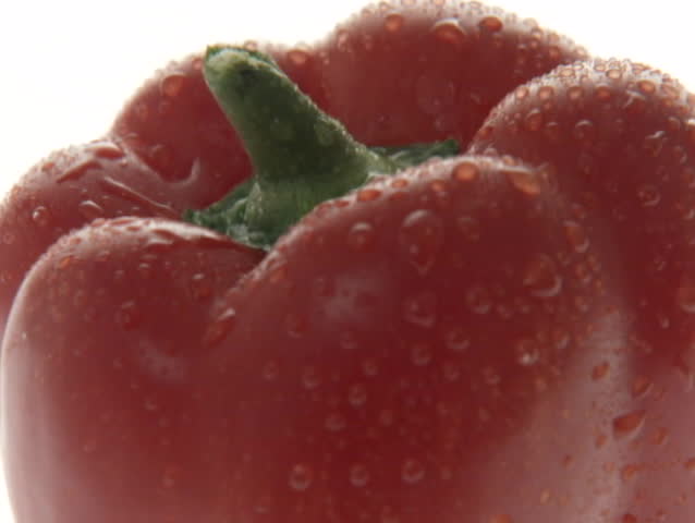 Water droplets glisten on a red bell pepper.