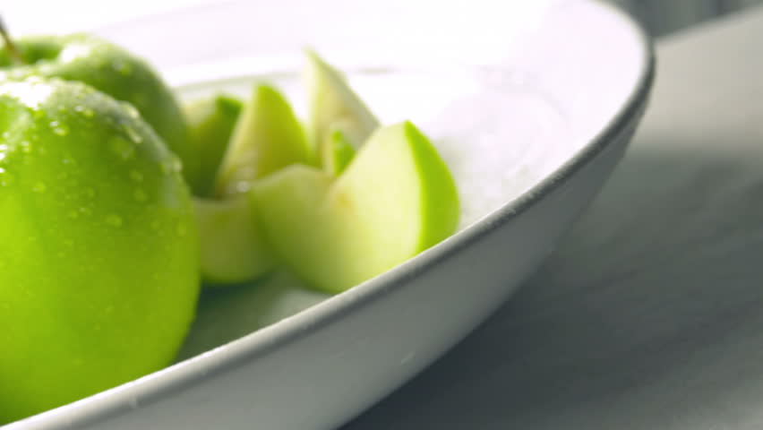 Fresh fruit and vegetables float through water in slow motion.