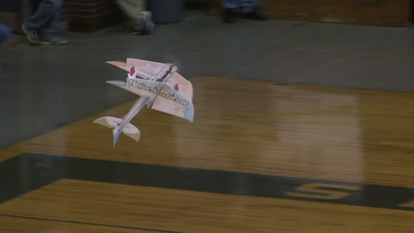 Radio-controlled foam model airplane performing aerobatic tricks at the competition venue