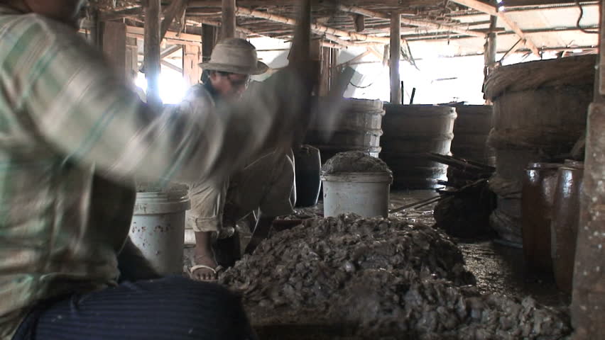Cambodian villagers smash the fish into a paste