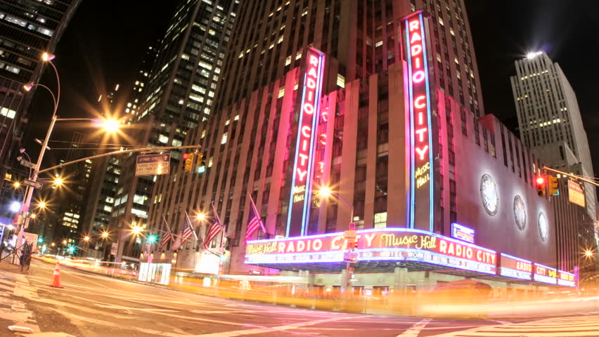 NEW YORK, NY - CIRCA 2010: Pink and gold lights merge in an accelerated shot of traffic passing in front of Radio City Music Hall at night circa 2010 in New York, NY.