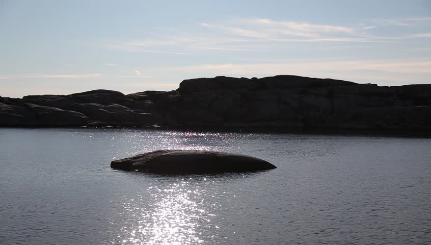 Sun reflects in the water at rocky coast Full HD