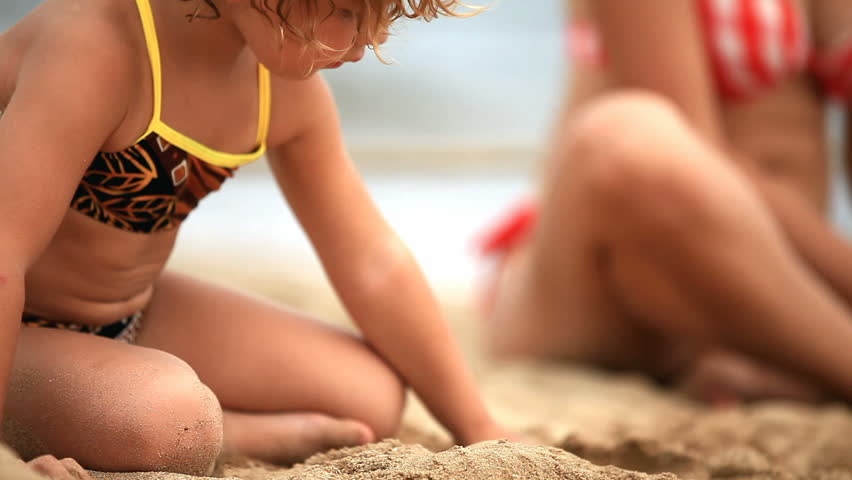 A little girl playing at the beach. 