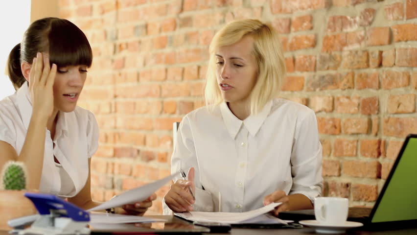 Two businesswomen in office stressful because of paperwork, camera stabilizer shot