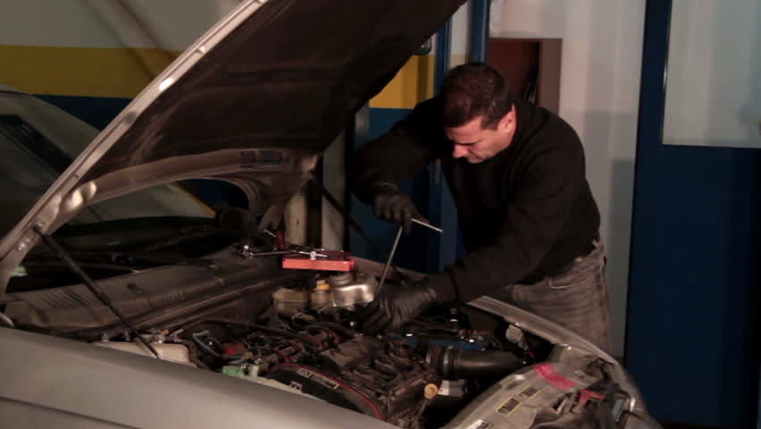 auto mechanic repairing a part of a car engine