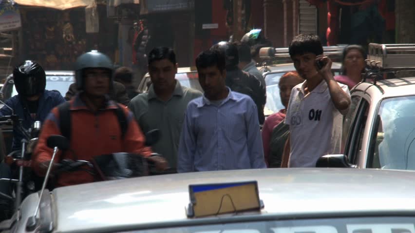 KATHMANDU - CIRCA 2010: People, cars and bikes circulate through the city circa 2010 in Kathmandu.