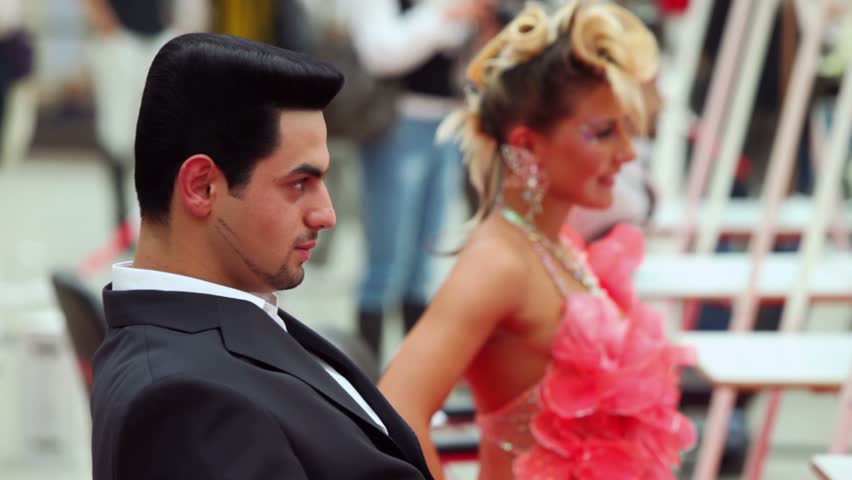 MOSCOW - OCTOBER 2: Man and woman in pink dress with beautiful hairstyle at XVII International Festival World of Beauty 2010 in exhibition complex Gostiny Dvor, on October 2, 2010 in Moscow, Russia.