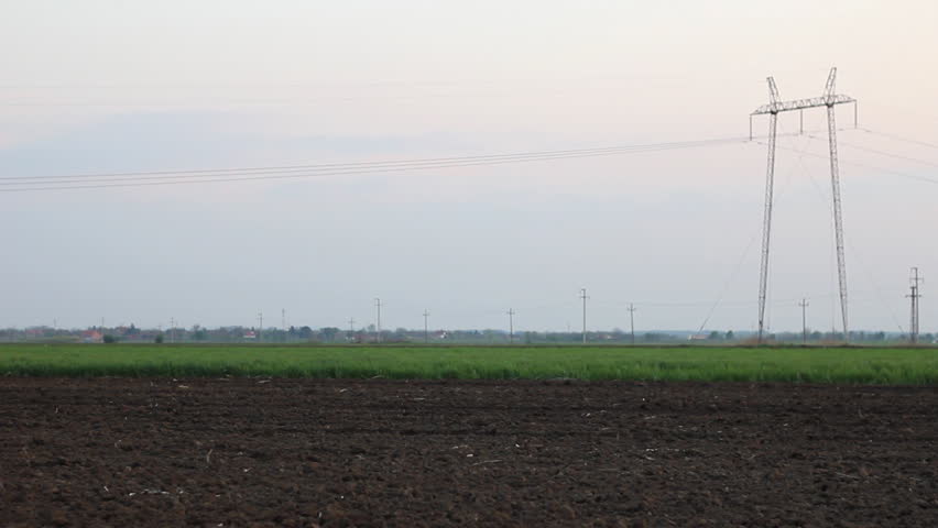Tractor in field spraying ground after sowing