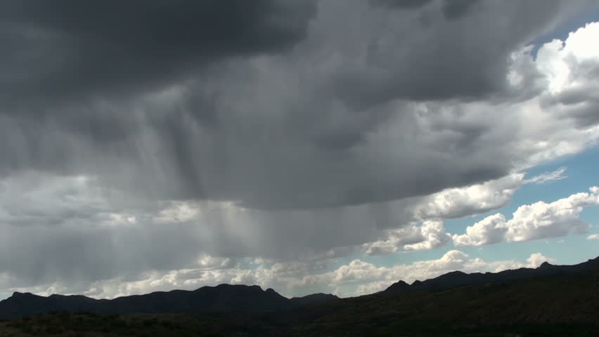 Time Lapse, Rain shafts sweep across silhouetted mountains dumping precipitation, followed by clearing blue skies. 1920x1080