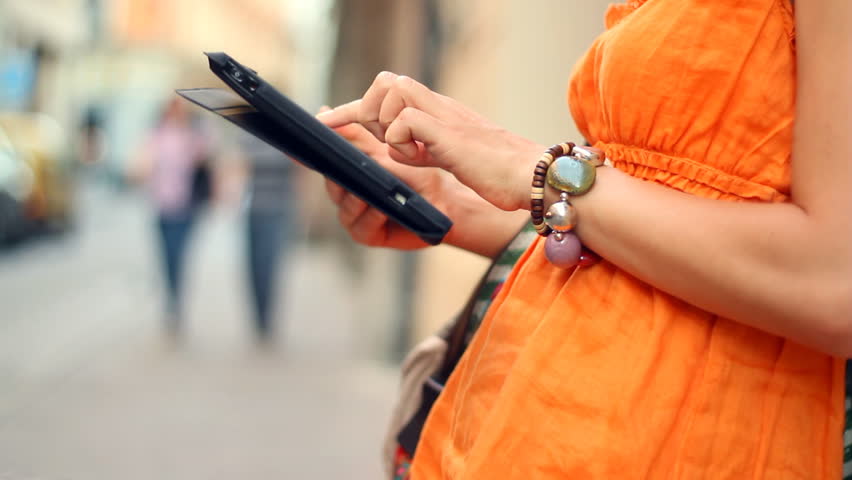 Happy woman with tablet computer in the city, camera stabilizer shot